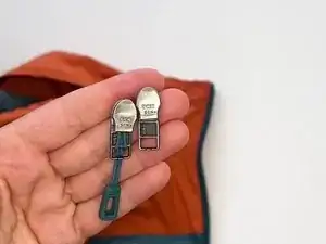 Making sure the new slider is oriented correctly, slide it onto the zipper tape.