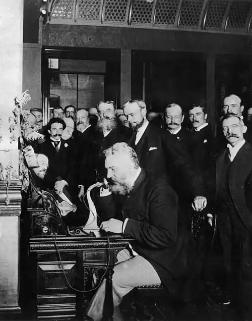 Alexander Graham Bell operating a long distance telephone in 1892.
