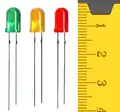 LEDs (light emitting diodes) of different colors. The color of the plastic that surrounds each diode isn't important, and some LEDs use clear plastic. There's a centimeter ruler at the right that tells you the plastic cases is are about 0.8 cm long.