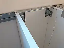 Every cabinet frame comes with two L-shaped brackets which are designed to lock into the rail. There are white plastic caps included to conceal the brackets and cutouts.