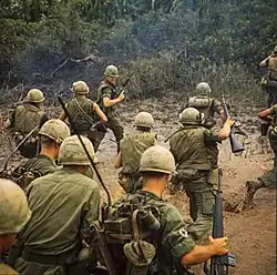 American troops wading through mud in Vietnam in 1967.
