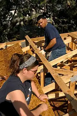 Atlantic Beach, Fla. (May 19, 2006) - Gunner's Mate 2nd Class Amy Hamilton, left, and Machinist's Mate Fireman Andy Gomez help build a house on a Beaches Habitat construction project. Sailors from the conventionally powered aircraft carrier USS John F. Kennedy (CV 67) volunteered to help those in need of a home. The construction site is part of a local Habitat for Humanity chapter, where community volunteers help build homes for those in need. U.S. Navy photo by Photographer's Mate 3rd Class Adam Herrada.
