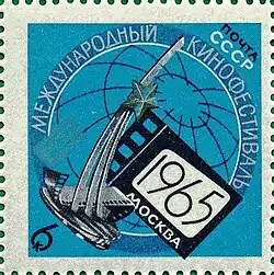 A USSR postage stamp with a ticket on which is written 1965 agqinst a blue background