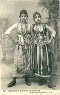 Postcard photograph of two dancing girls posing in a dance costume with the name of "Egyptian types and scenes" (c. 1900).