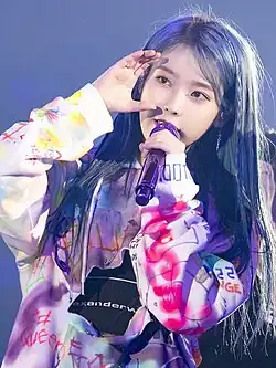 IU sings into a microphone.