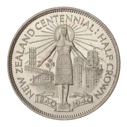 A coin featuring the Coat of Arms of New Zealand, surrounded by Maori wood carvings and the encircling text "NEW ZEALAND HALF CROWN 1933."