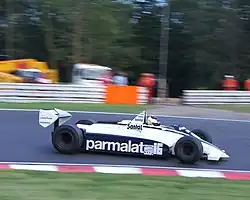 A mid-engined single-seater racing car with large aerodynamic wings