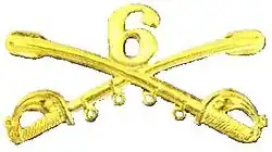 A computer-generated reproduction of the insignia of the Union Army 6th Regiment cavalry branch: The insignia is displayed in gold and consists of two sheafed swords crossing over each other at a 45° angle pointing upwards with a Roman numeral 6