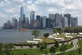 Lower Manhattan from Outlook Hill's summit, the tallest artificial hill on the island; open space, bike paths and a Staten Island Ferry boat are visible