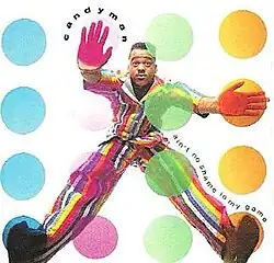 A man wearing a multi-colored striped suit has four colored circles in front of him: blue, magenta, green and orange. He has his right hand and foot on the orange circles, and has his left hand and foot on a magenta and blue circle respectively.