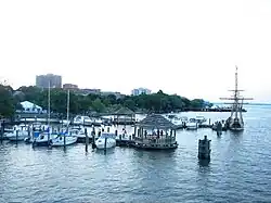 Modern photo of piers extending into quiet water with a dozen boats docked to them.