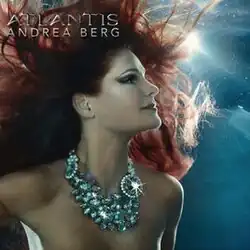 A red-haired woman underwater looking up. She is wearing a shiny pearl necklace. The words "Andrea Berg Atlantis" are written in silver in the top left corner.