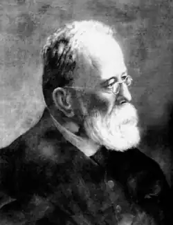 Portrait photograph of Anselmo Lorenzo, wearing a beard and glasses