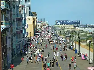 Many people walking on a boardwalk at the beach in Atlantic City, New Jersey