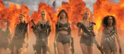 A shot of the "Bad Blood" music video showing Swift and her crew walking in front of an explosion