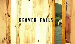 Beaver Falls written in black letters against a wooden door, slightly ajar, showing a lake.