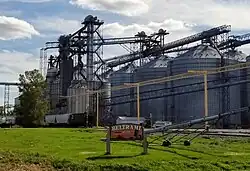 sign reading "Beltrami established 1883". In the background, grain silos and grain elevators are visible.