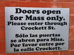 Spanish-English sign at Cathedral Santuario de Guadalupe in Dallas, Texas; the congregation has both English and Spanish speakers.