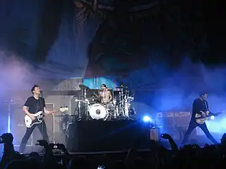 Blink-182 in 2011. Left to right: Mark Hoppus, Travis Barker, and Tom DeLonge.
