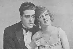 Clean-shaven white man in dinner jacket with young white woman in evening gown