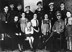 13.8.1943, The political Nazi leader Reichel (from Erdmannsdorf in Saxony) with his wife and twelve children all dressed in Nazi Party or military uniforms. The mother is decorated with the Cross of Honor of the German Mother.Five sons are with the German Wehrmacht; the sixth is with the Reich Labor Service. The smaller children are all members of Nazi youth organizations. The youngest girls have Wolfsangel symbols on their dresses; a sign for members in NS-Frauenschaft's Deutsche Kinderschar for children aged between 6 and 10. Photo: Bundesarchiv (German Federal Archives)