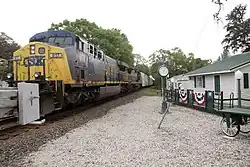 Freight train passing a small building