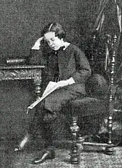 young lad in Victorian dress, sitting at a desk