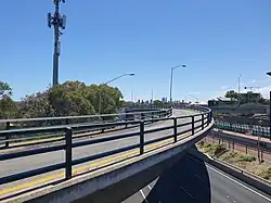 Curved concrete bus bridge over and down into a freeway