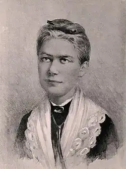 Bust length black and white portrait of a woman wearing a shawl with her hair pinned up