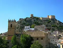 Stone Church in foreground, Hermitage in middle distance with Castle on high under a deep blue sky
