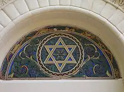 Tile art above right-hand doorway (west side).