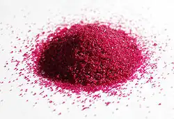 a pile of red granules on white paper