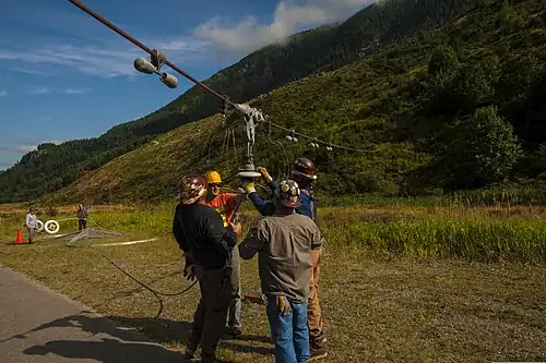 Contractors repairing one of the 1.6&nbsp;km (1 mile) long antenna wires that span the valley, which here is lowered to the ground for access.