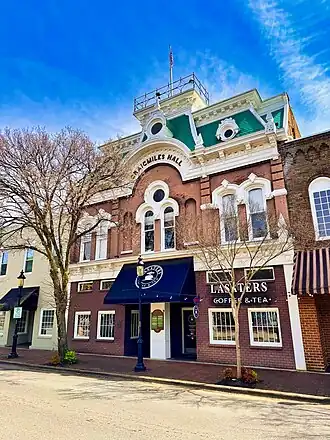 Three story building with an elaborate roof, including a widow's walk