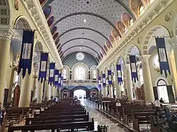 Church interior facing the choir loft. Note the arcade, clerestories, and rose window.