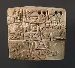 A proto-cuneiform tablet, Jemdet Nasr period, c. 3100–2900 BC. A dog on a leash is visible in the background of the lower panel.[32]