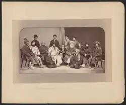 Dōst Moḥammad Khan seated slightly to the right of center in this photograph. To Dōst Moḥammad's right, the first figure in a white chapan (overcoat) is his son and successor Sher ʻAlī Khān (1825–1879), who ruled Afghanistan from 1863 to 1879. Abd al-Raḥmān Khān (c. 1844 – 1901), the grandson of Dōst Mohammad and future "Iron Amir" of Afghanistan, is on Dōst Moḥammad's far left. Photograph by John Burke.