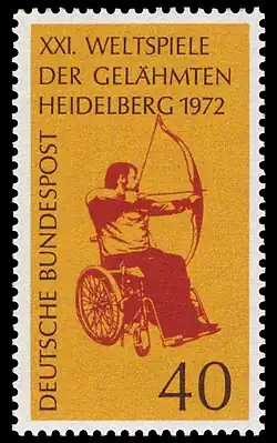 A postage stamp featuring a red image of an archer with drawn bow sat in a wheelchair, on a yellow background