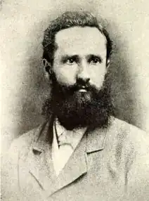 photograph of black-haired, bearded man