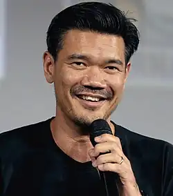 Destin Daniel Cretton speaking into a microphone at Comic-Con in 2019