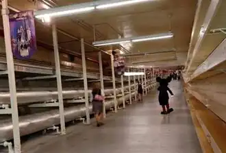 Disney Utilidor underneath the Magic Kingdom, with a cast member dressed as Mickey Mouse walking away from camera