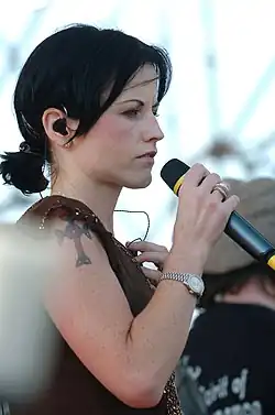 Dolores O'Riordan looking to the right holding a microphone