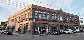 Photograph of a two-story, brick commercial building on an urban street corner