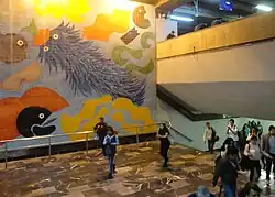 A tile mural featuring colorful abstract creatures floating around the artwork.