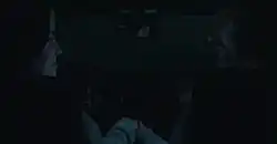 A man and woman hold hands as they smile at each other