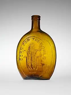 gold flask with ear of corn on it