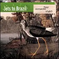 A red-crowned crane facing left to a lake, with a forest in the background