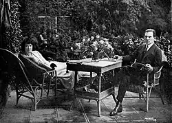 Black and white photograph of a man and woman in formal 1920s attire sitting together