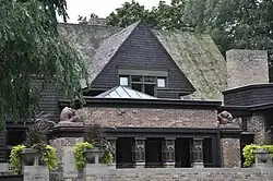 The entrance to the studio on Chicago Avenue. There is a partition wall in front of the entrance itself, which is through a loggia with columns. Above the loggia is a triangular gable.