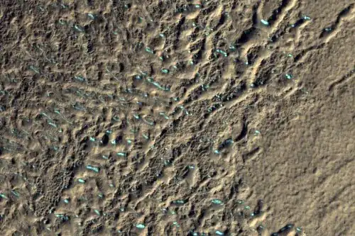 Surface of debris apron in Terra Cimmeria, as seen by HiRISE, under the HiWish program. Colored parts may be frost deposits.